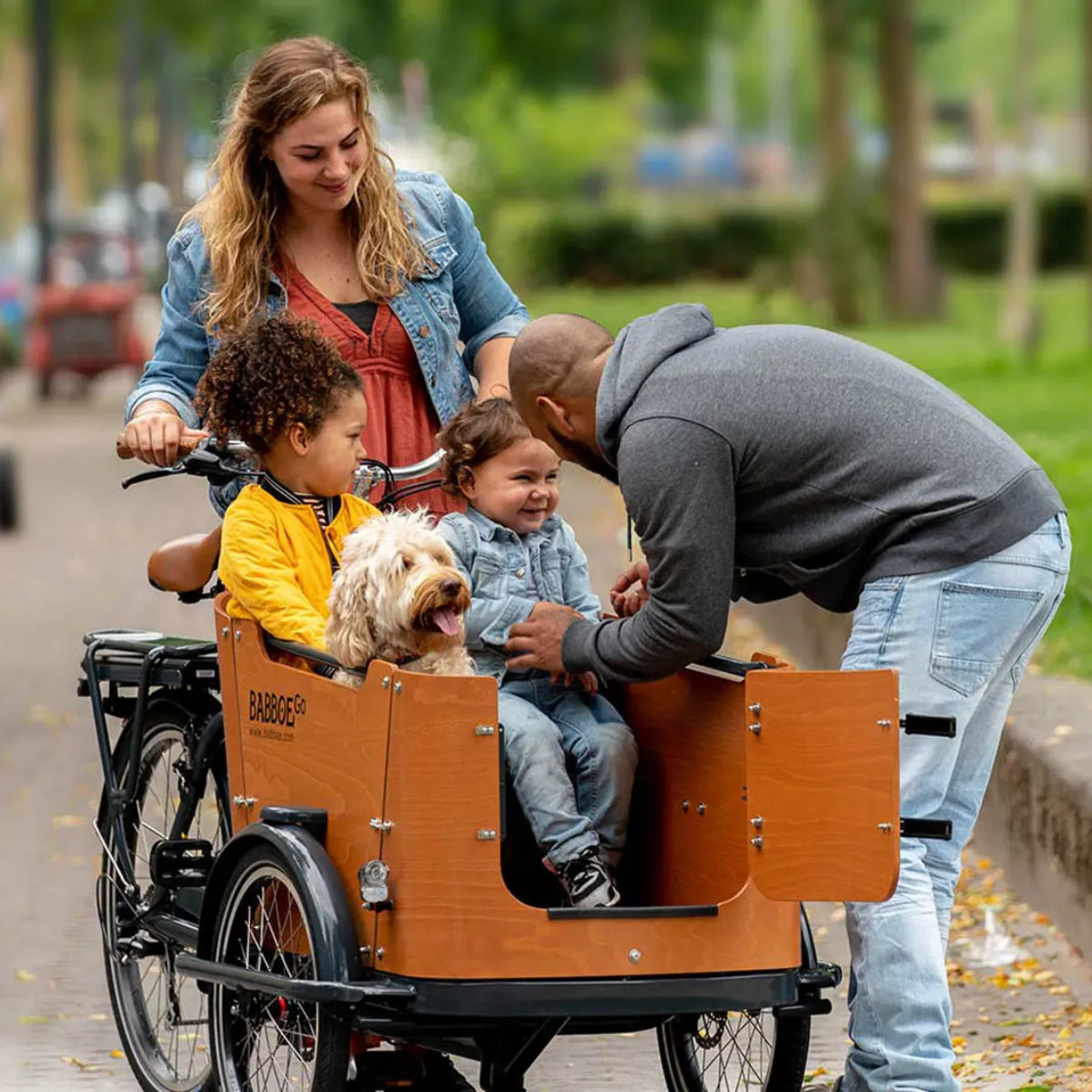 Couple with Kids and a Dog Riding a Babboe Cargo Bike