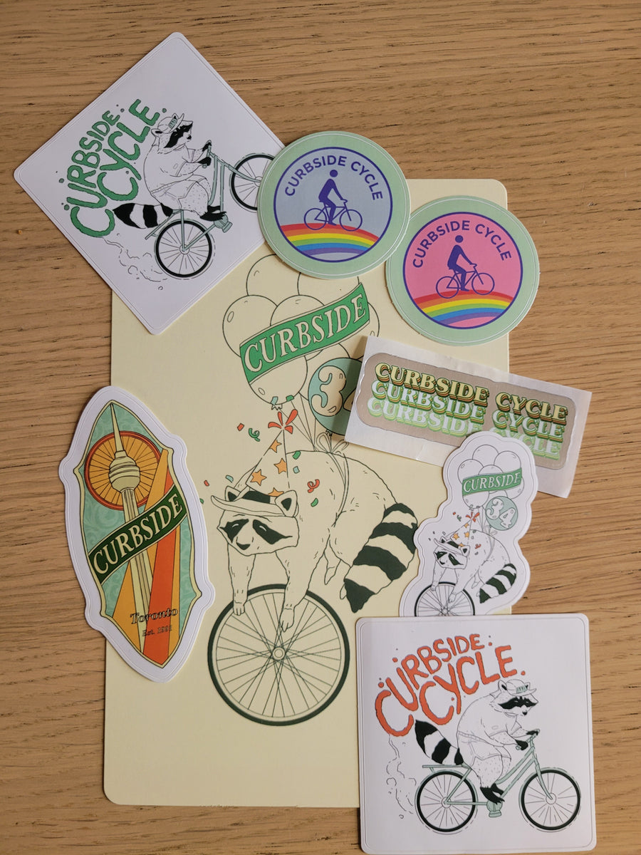 Collection of colorful stickers with bicycle-themed designs on a wooden surface