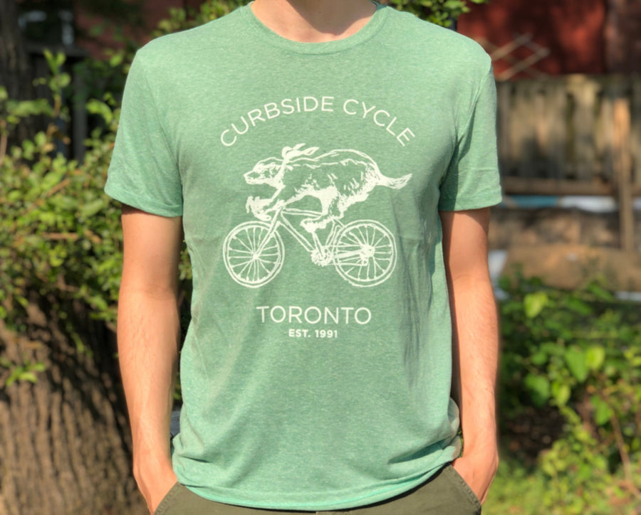 Curbside Cycle Cycling Badger T-Shirt in Colour Green on Male Model Outside in the Sun