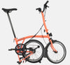 2023 Brompton C Line Urban High Handlebar 2-speed folding bike in Fire Coral - kickstand mode